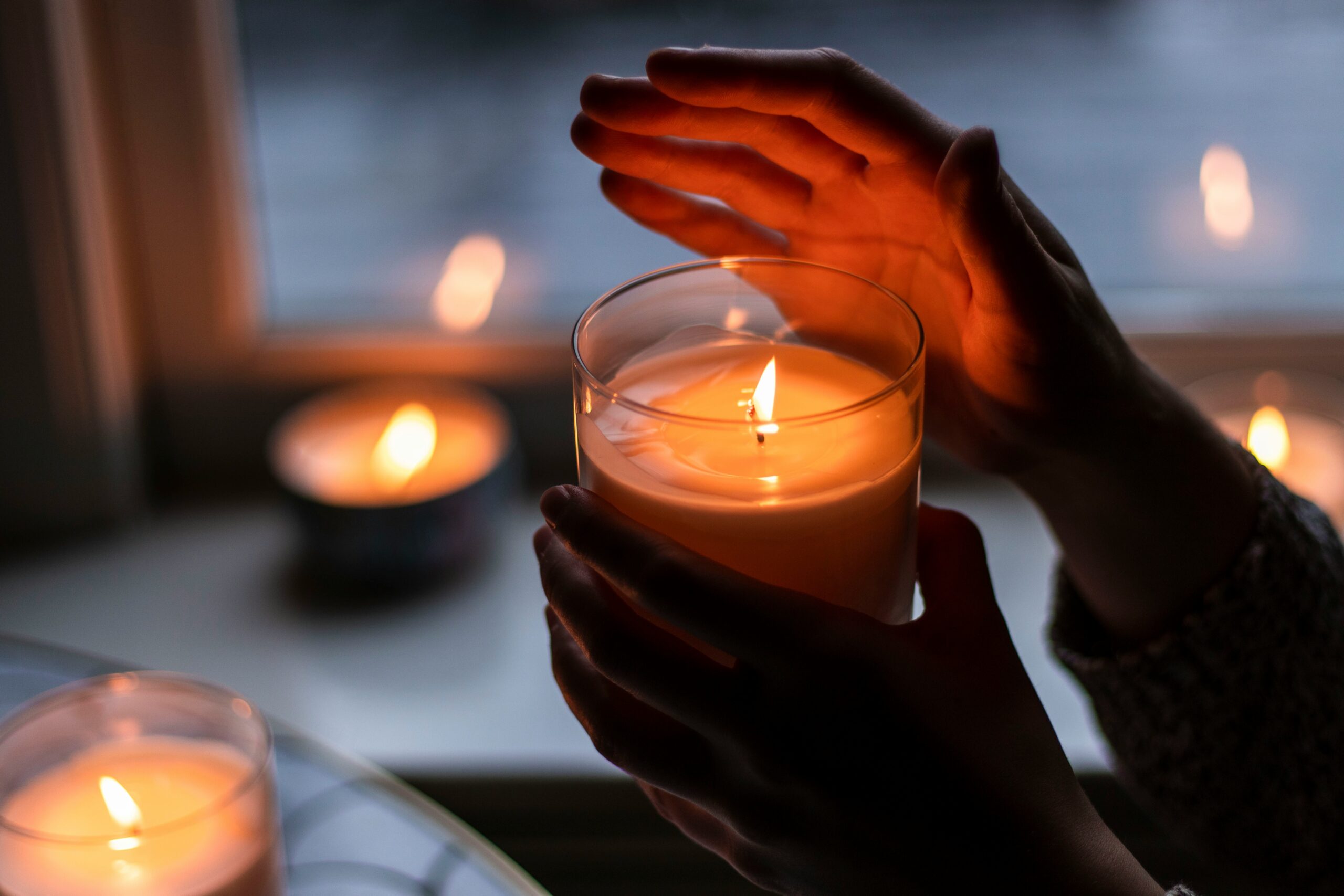 A person holds a candle in their hands